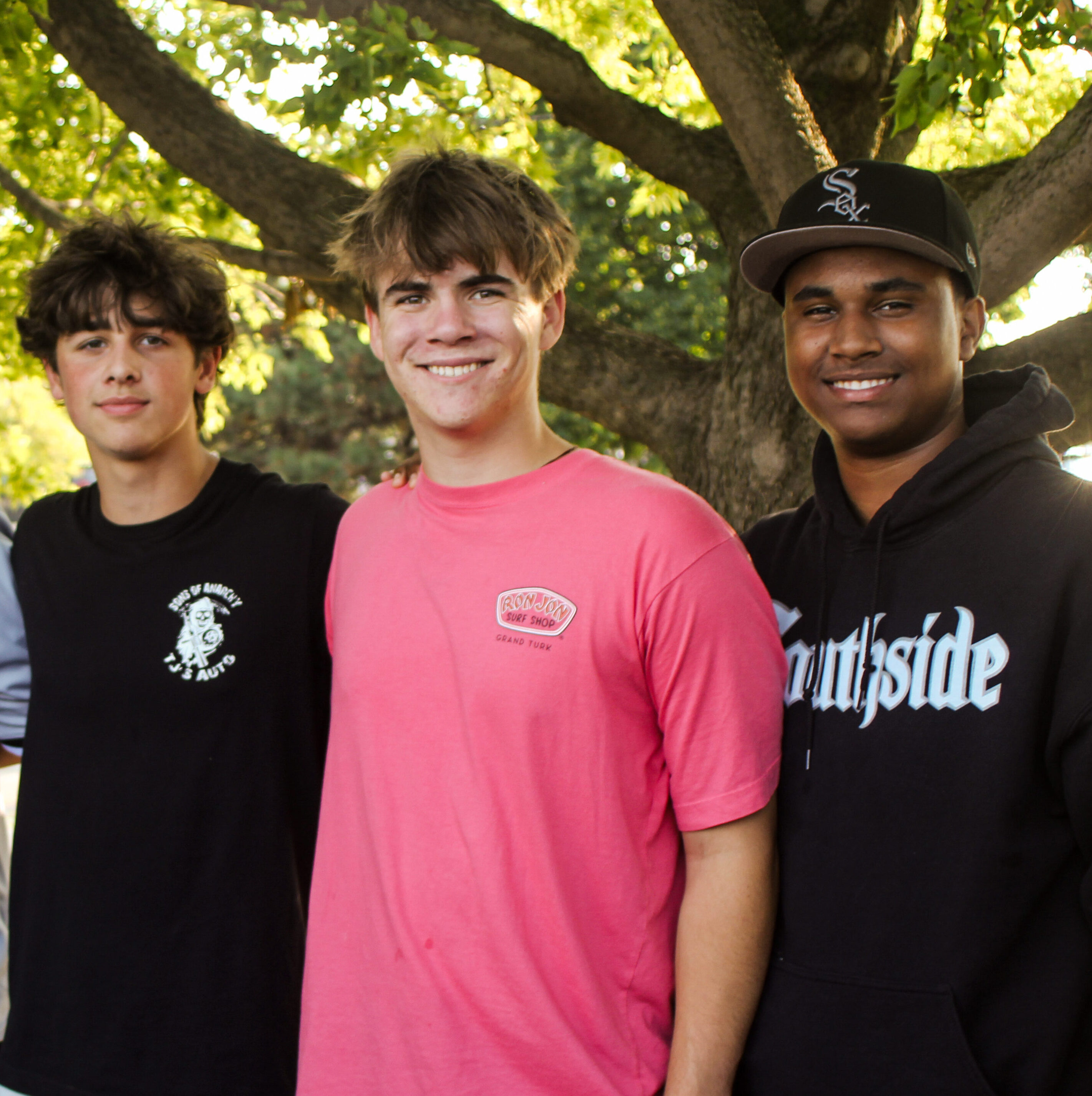Five young men standing together smiling for a photo